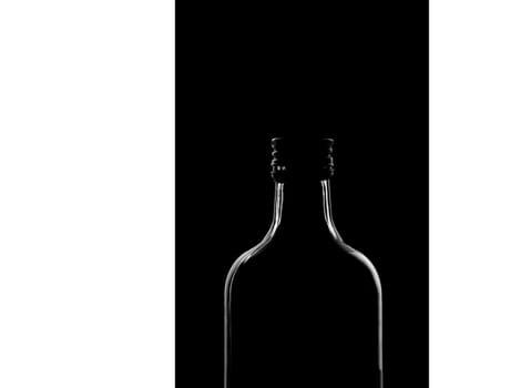 half a bottle on a black background. Only the silhouette is visible. High quality photo
