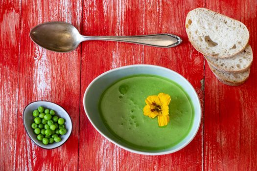 creamy pea soup on red wood