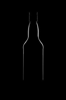 Silhouette of a bottle with a beautiful shape on a black background. High quality photo