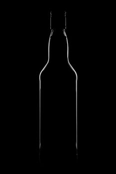 Silhouette of a bottle with a beautiful shape on a black background. High quality photo