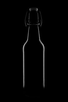 Silhouette of a bottle with a beautiful shape on a black background. High quality photo