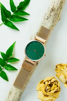 Closeup minimal fashion wristwatch for unisex on white background with flowers