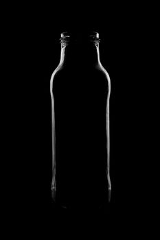 Silhouette of a bottle with a beautiful shape on a black background. High quality photo