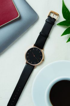Closeup minimal fashion wristwatch for unisex on white background with flowers and computer