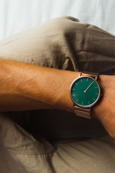 Closeup minimal fashion wristwatch for unisex. Man wearing a watch