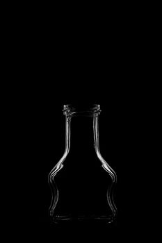 Silhouette of a bottle with a beautiful shape on a black background. High quality photo