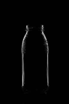 Silhouette of a bottle with a beautiful shape on a black background. High quality photo