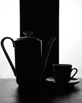 concept kettle and cups with saucer on a black white background. High quality photo