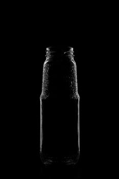 Silhouette of a bottle with a beautiful shape on a black background. High quality photo