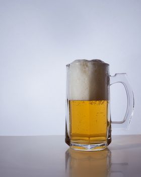 silhouette of a beer mug with amber yellow beer, which is poured with foam. Hight quality photo