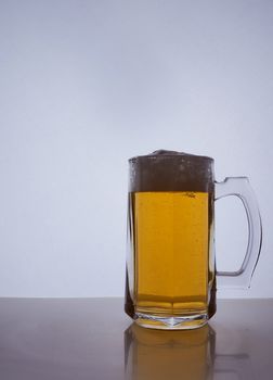 silhouette of a beer mug with amber yellow beer, which is poured with foam. Hight quality photo