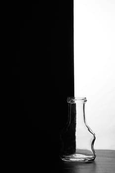 A small bottle on a black and white background. Half black and half white. High quality photo