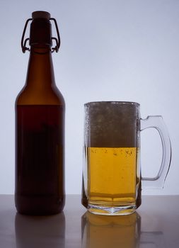 colored silhouette of a beer bottle with a cork and beer mug with beer poured into it on a black white background. Hight quality photo