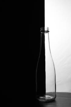 A small bottle on a black and white background. Half black and half white. High quality photo