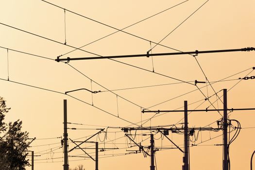 Tram  cables at sundown.Tramway overhead traction photo. Electric, transport wires photography.  Transportation infrastructure at sunset in downtown . Urban traffic wire structure.