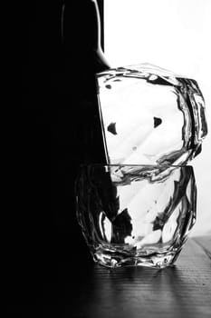 glasses of whiskey lie on top of each other. There's a bottle of whiskey next to me. Black white background. Silhouettes. High quality photo