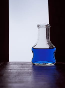 chocolate cream bottle on a black white background with blue liquid . Hight quality photo