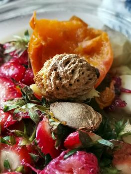 Fruits scrap and peel photography. Groceries composting in kitchen. Food waste recycling. Pit of peach and strawberries heads. Pile of bio garbage and rubbish close up photo. 