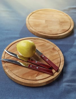 lemon and knives with a wooden handle lie on the tray. Next to another tray to insert the text composition closeup photo