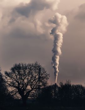 Smoke emission from chimney. Cause of global warming. Conception of air pollution and smog issue. Factory steam contaminate atmosphere. Fumes from burning carbon cause climate change problems .