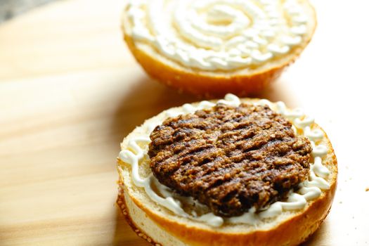 beef patty lies on a bun for a burger closeup photo