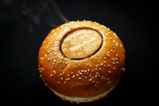 delicious burger bun with space to insert logo on black closeup photo