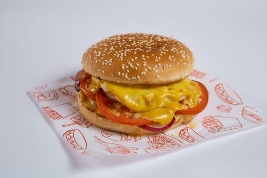 cheeseburger lies on a paper napkin. Isolate closeup photo