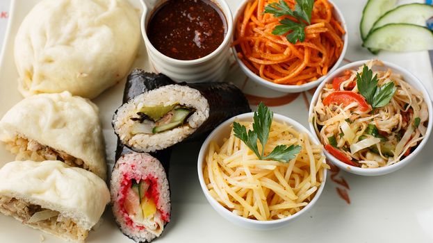 Korean nazionic dishes on a white plate. Pies, carrots and sauerkraut top view photo