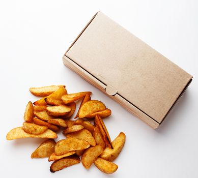 potato wedges and a cardboard box on a white closeup photo