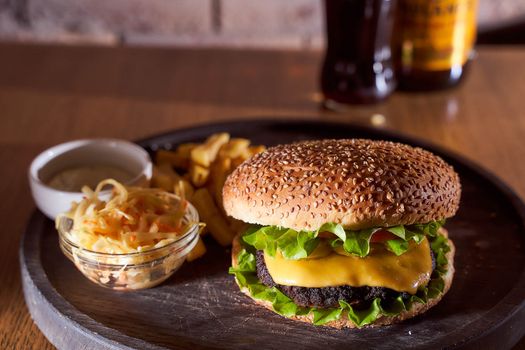 burger with sesame seeds with fries and salad of cabbage closeup photo