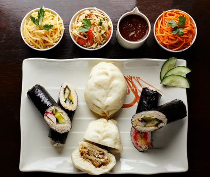 Korean nazionic dishes on a white plate. Pies, carrots and sauerkraut top view photo