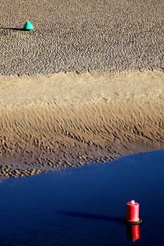 Two buoys opposite each over as an abstract beach sand background stock photo