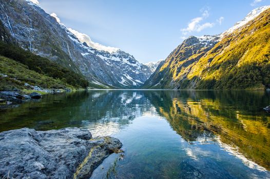Peaks of Darran Mountains reflecting in a Lake Marian, Fiordland national park, New Zealand South island