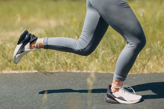 Runner woman in running shoes closeup of woman sporty legs. Female jogging