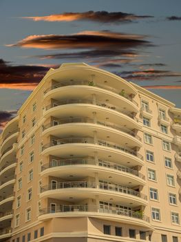 A modern stucco condo building with Large Curved Balconies