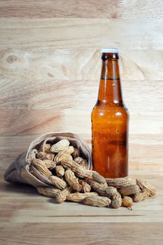 Peanuts and beer on wood background