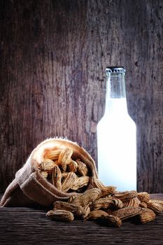Peanuts and beer in on wood background