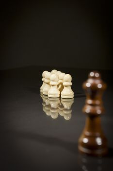 Chess pieces on a black reflective surface