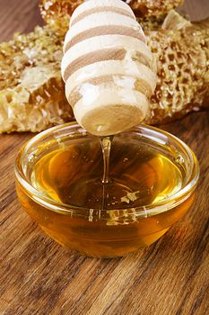 Yellow Honey and Honeycomb slice on a wooden table