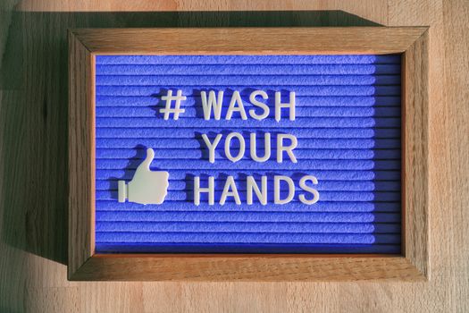 Wash your hands hashtag message felt sign at business store good hand hygiene for coronavirus prevention. Online message for social media for COVID-19 protection.