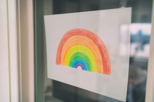 Covid-19 Rainbow children painting hanging in window as social media hope message to spread positivity in community for coronavirus prevention. Kids drawing.