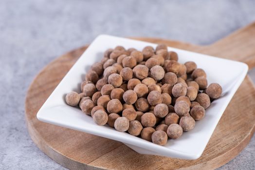 Dry raw brown tapioca pearls isolated on gray cement concrete background, close up, ingredient of making bubble boba tapioca milk tea.