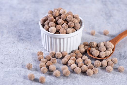 Dry raw brown tapioca pearls isolated on gray cement concrete background, close up, ingredient of making bubble boba tapioca milk tea.