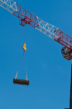 The crane lifts a heavy load on a hook.