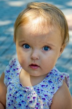 A cute little girl looks into the frame. Soft focus.