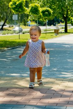 A little girl walks along the sidewalk and cries.