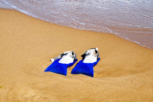 flippers on the sand against the background of the sea, copy space