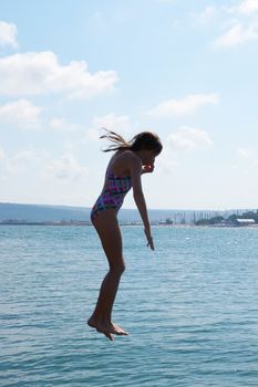 girl dives into the sea against the horizon