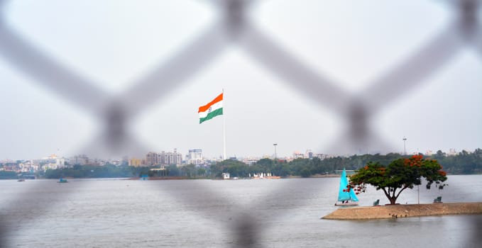Indian flag waving in a air on independence day of india. view of flag through wire Fench