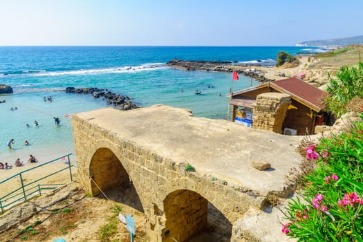 Achziv, Israel - July 22, 2020: View of an old building and the coast, with visitors, in Achziv national park, northern Israel